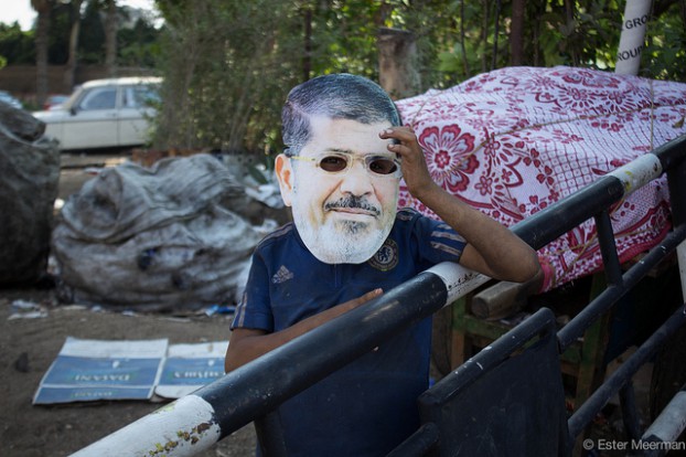 Een kind draagt een masker met het gezicht van de afgezette Egyptische president Morsi. Foto Ester Meerman